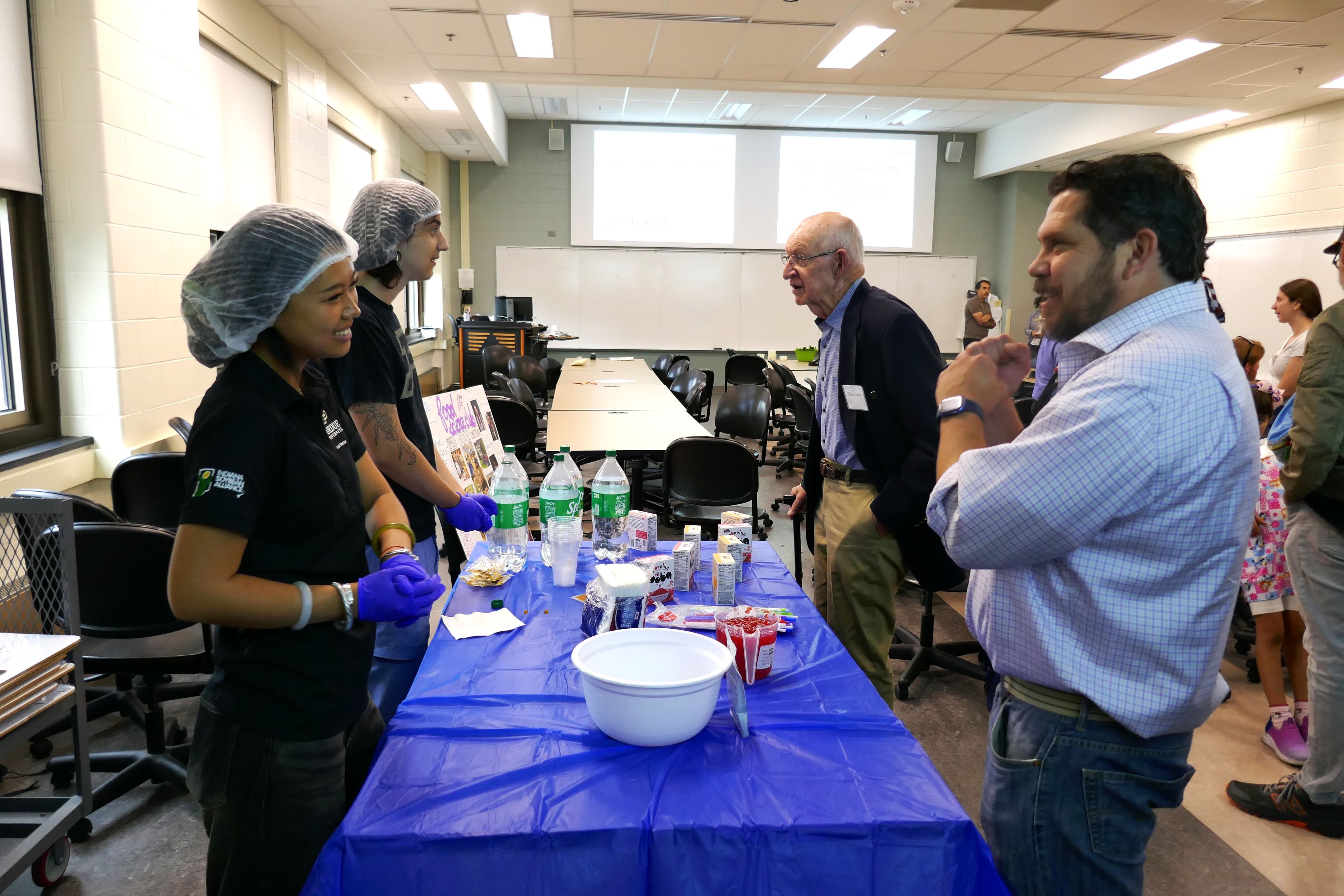 Student explains popping boba to an attendee
