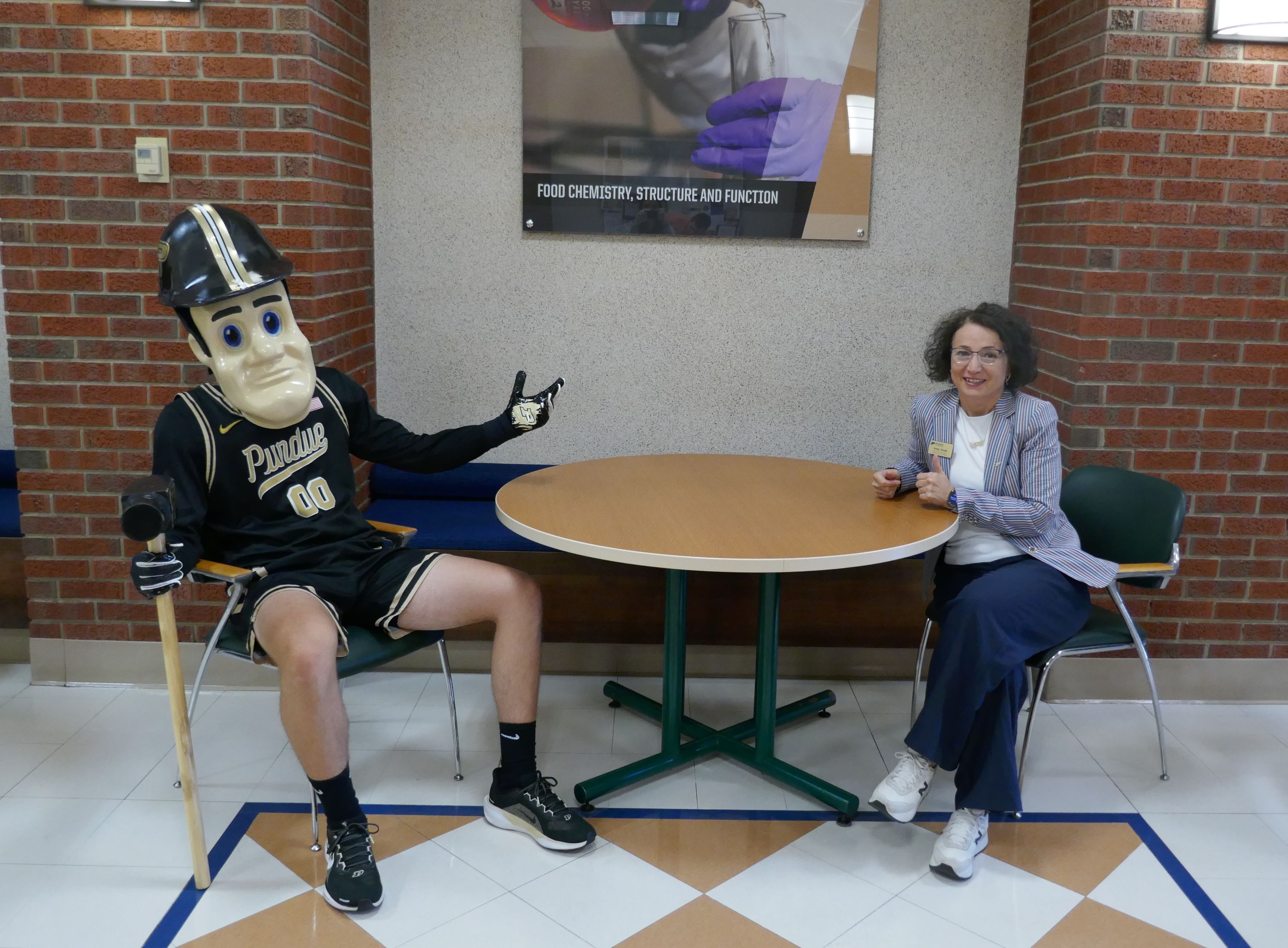 Woman sitting at a table with Purdue Pete
