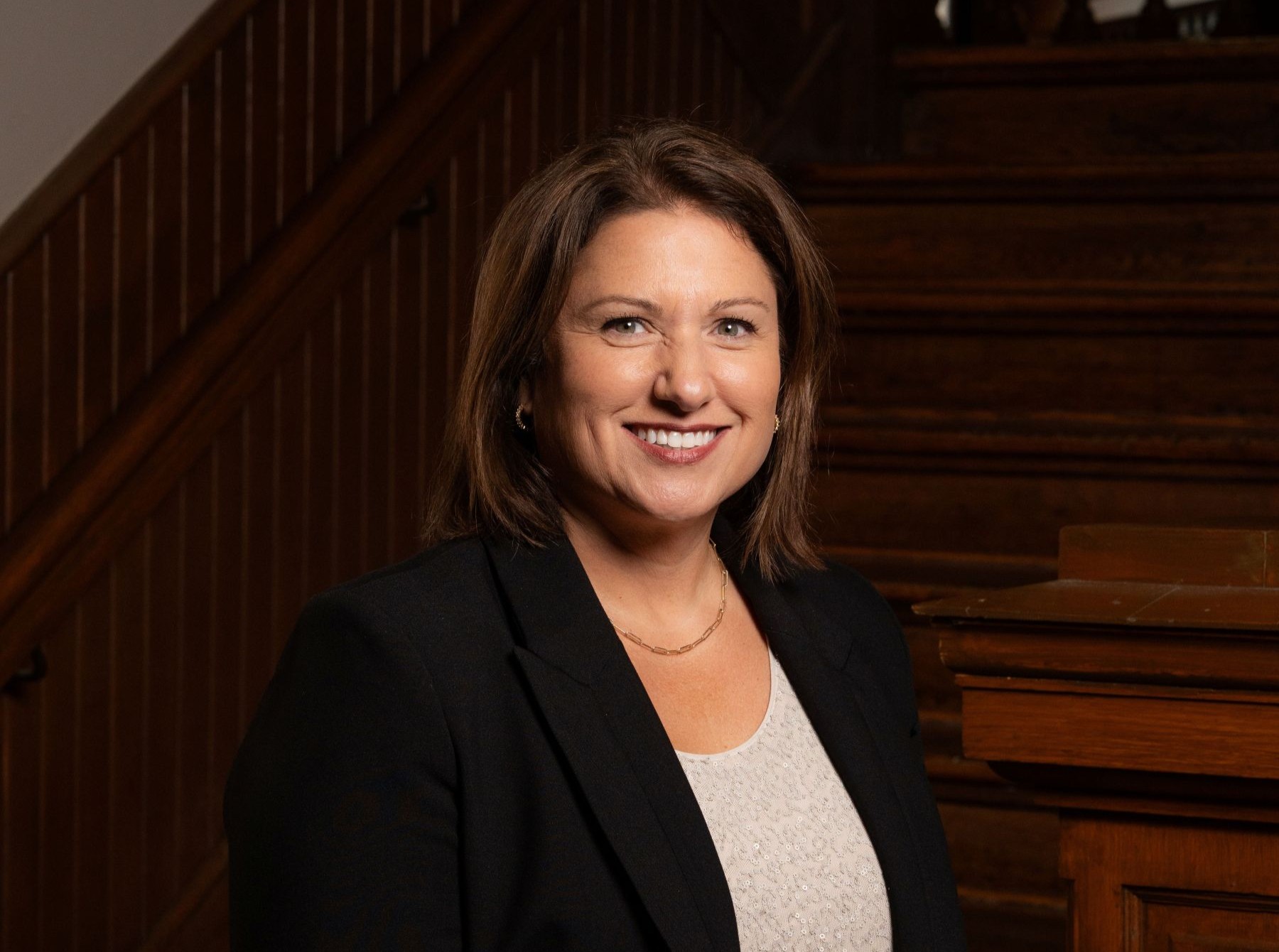 Woman wearing a suit and smiling at the camera