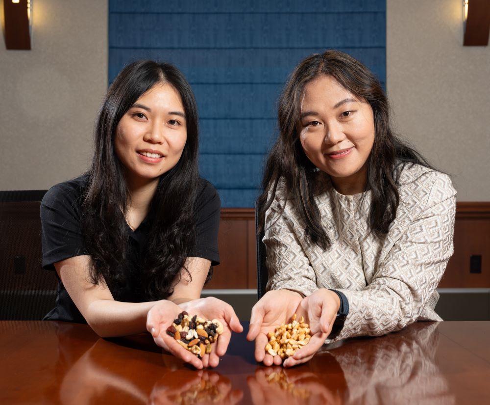 Dr. Betty Feng and Han Chen holding tree nuts