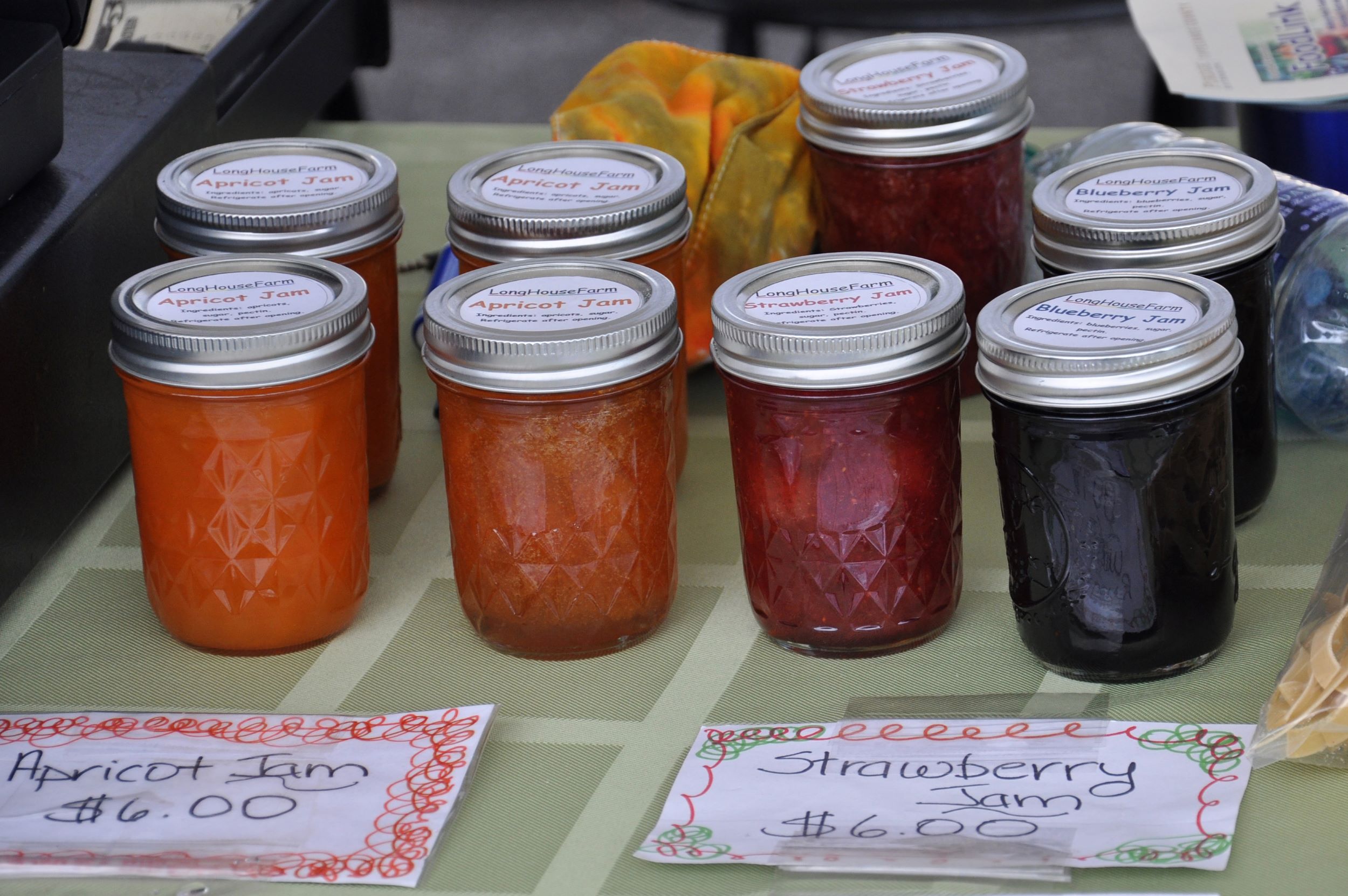 Several jars of jam for sale at a farmers market
