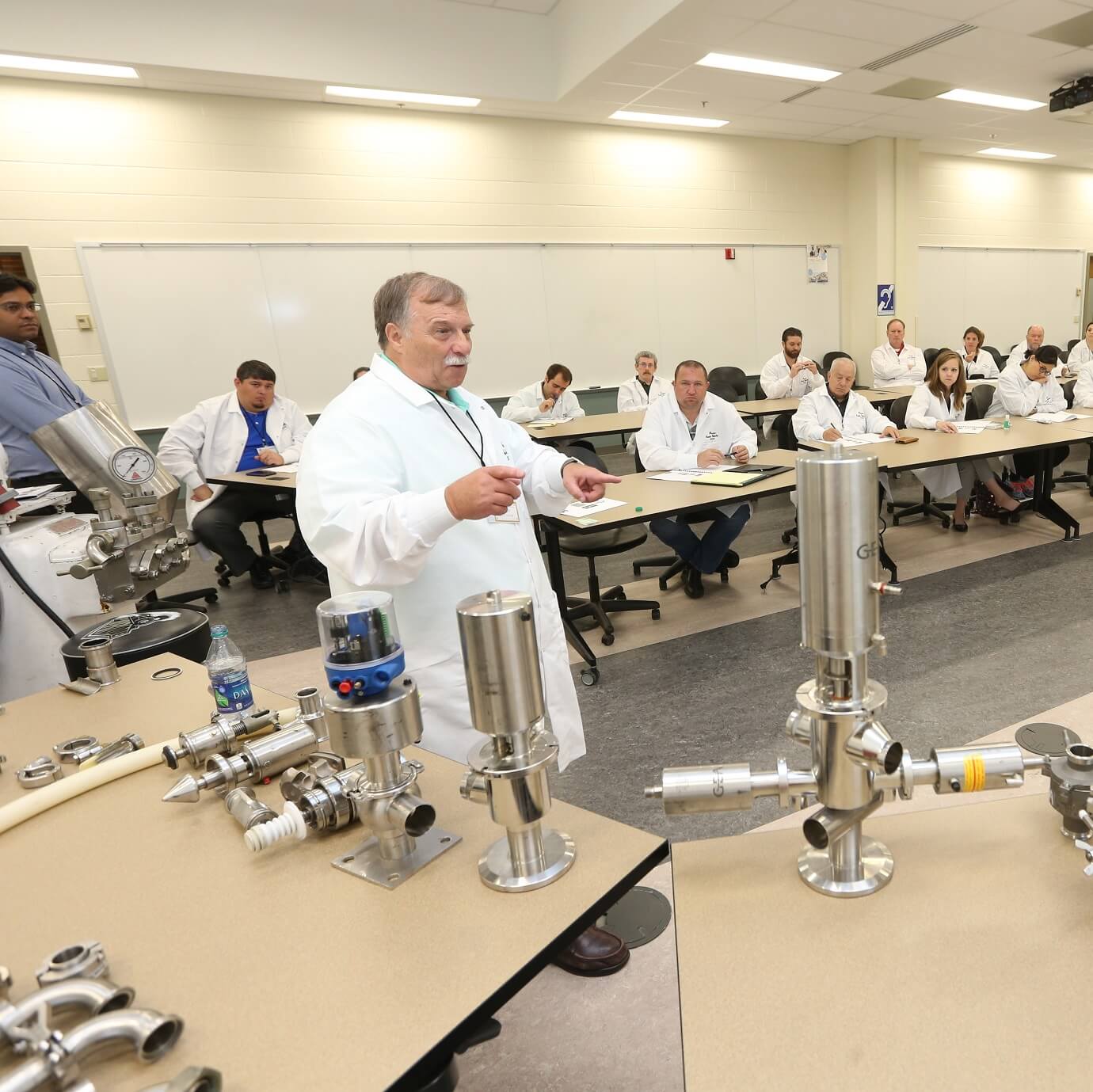 students in a classroom wearing lab coats