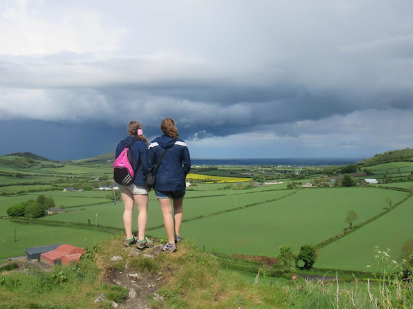 Two students looking at the landscape on top of the hill