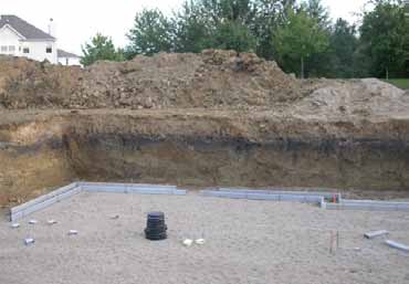 Construction site with exposed subsoil layers, showing disturbed soil conditions that can reduce turf nutrient availability.
