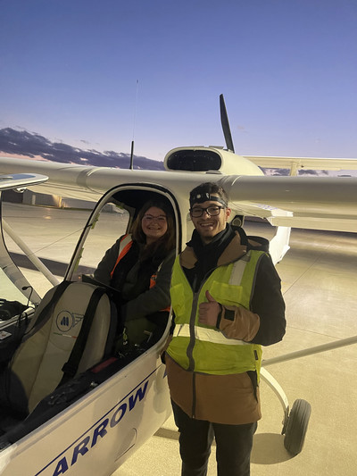 Kira and the pilot, Ryan Mittman, on tarmac with the plane. 