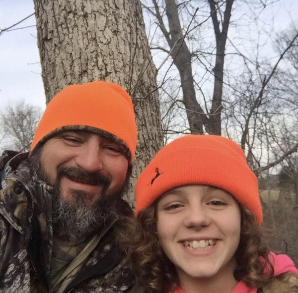 Father and daughter taking a selfie in a tree stand. 