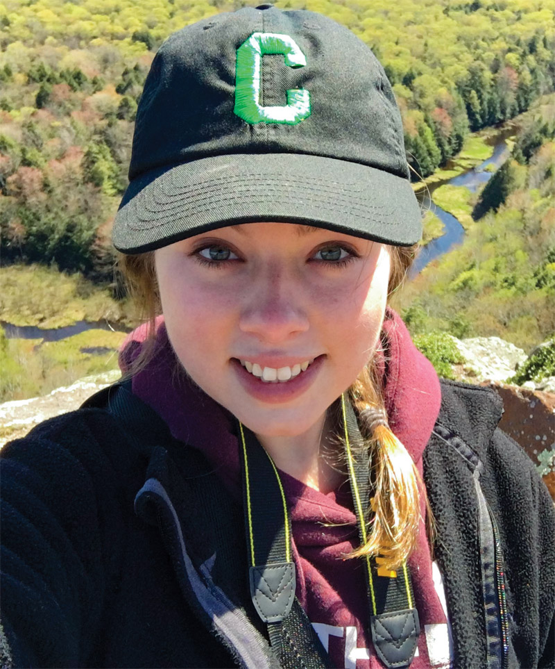 Lexi Eiler takes a selfie overlooking a creek and valley