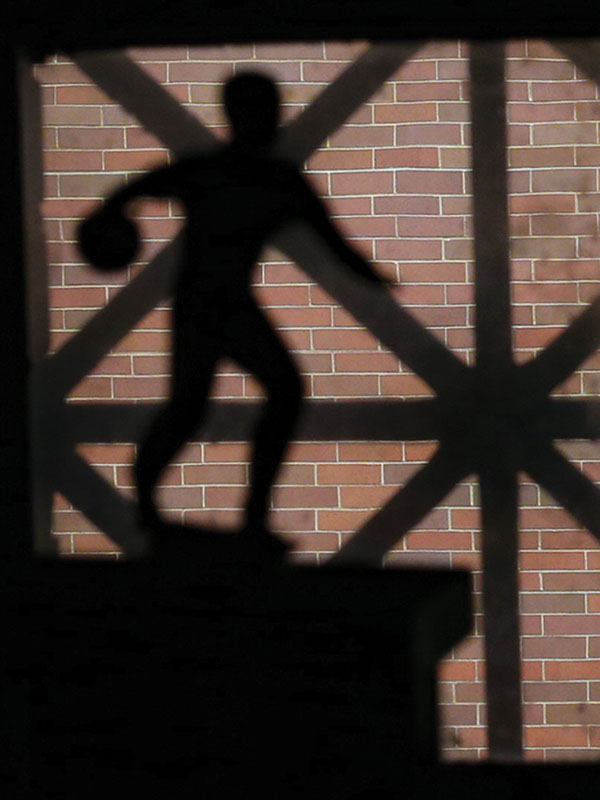 Shadow of bowling trophy cast against brick