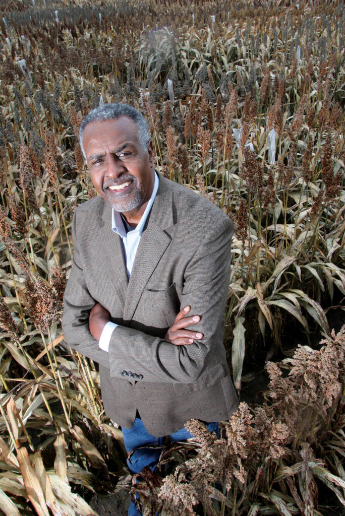 Dr. Gebisa Ejeta stands in a field