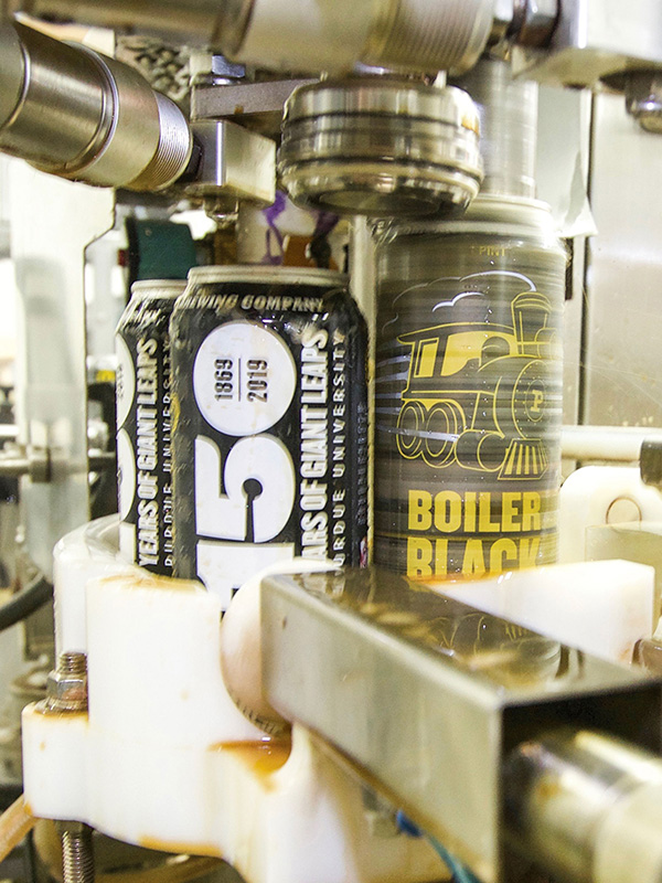 beer being canned on machines at brewery