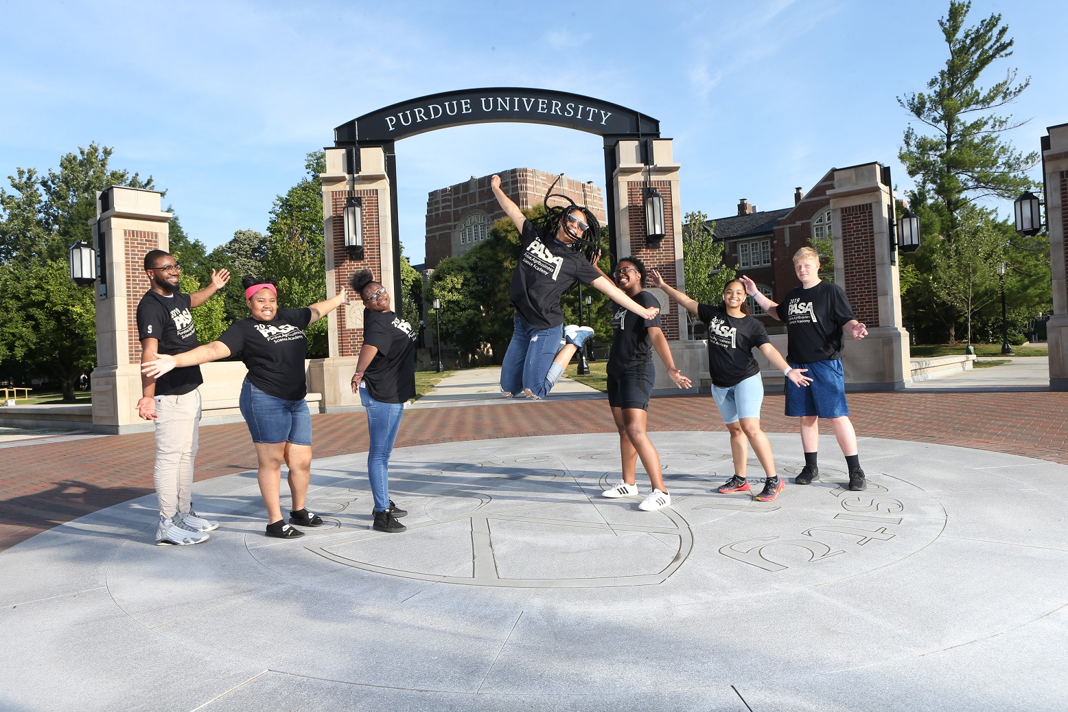 students jumping in front of arch