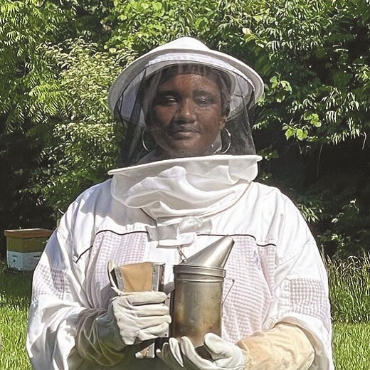 keirstyn in a bee keeper suit holding honey