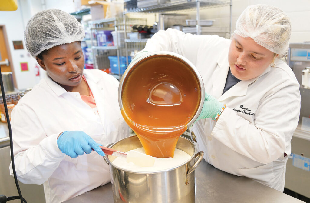 two people in a lab pouring caramel