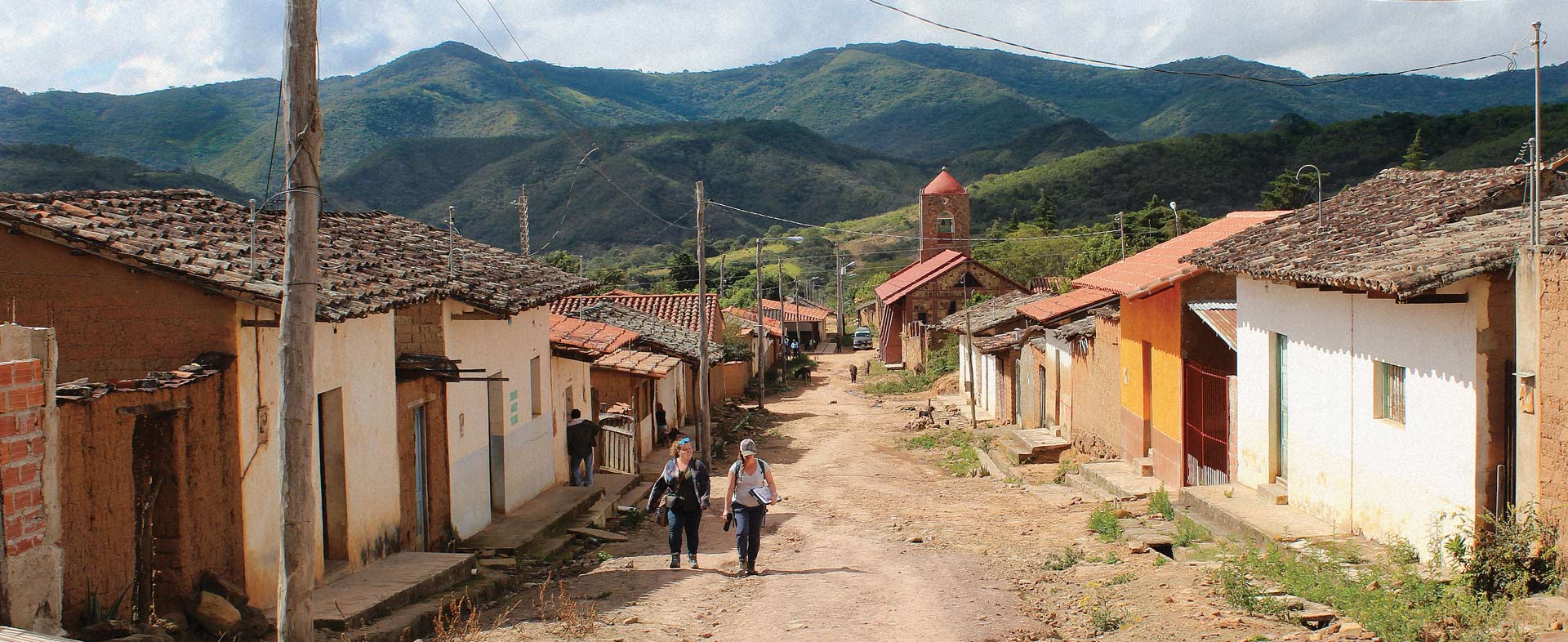 2 people walking through a village