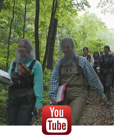 Students at summer practicum walking in forest, YouTube icon.