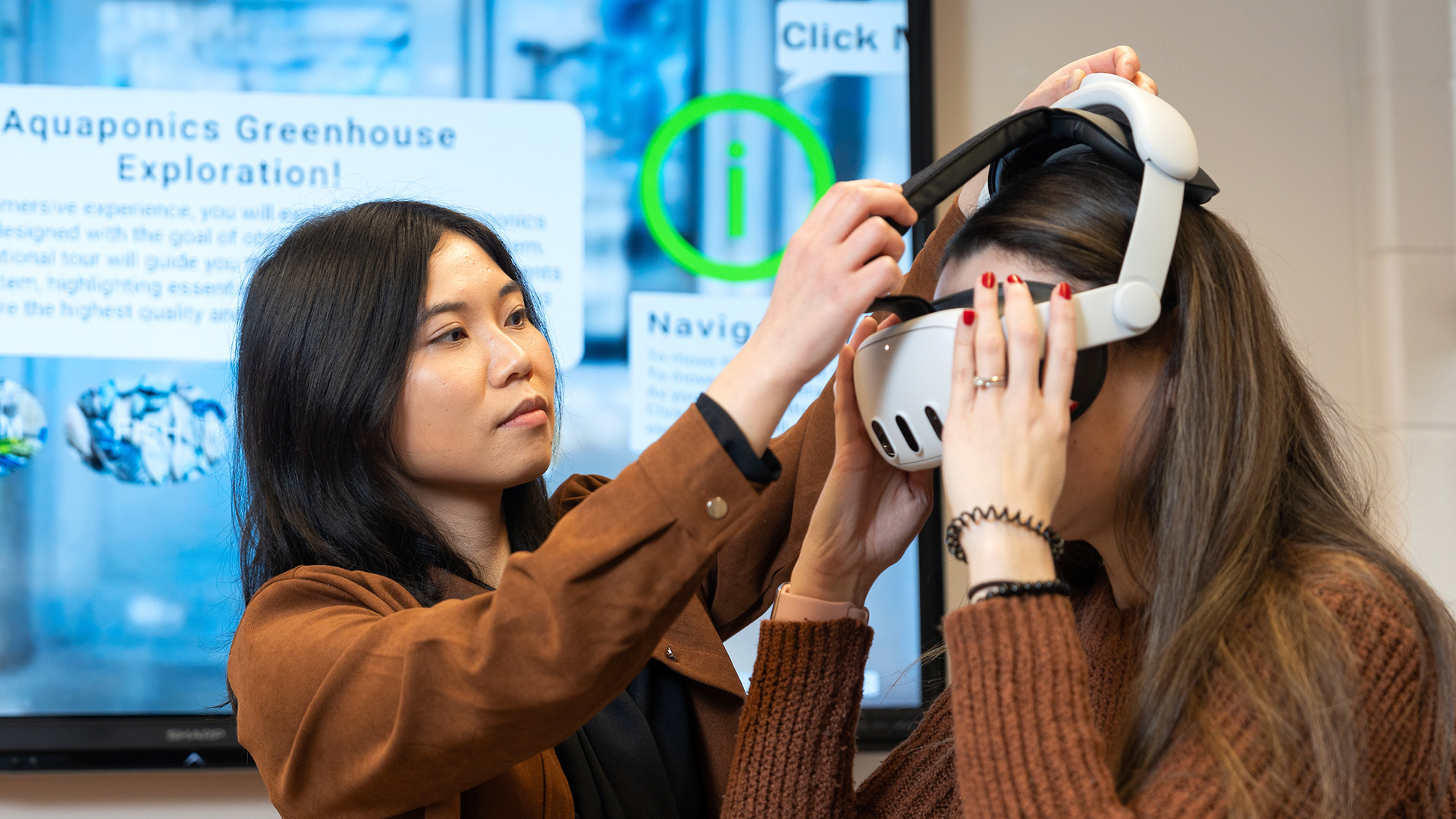 Student assisting someone with a VR headset