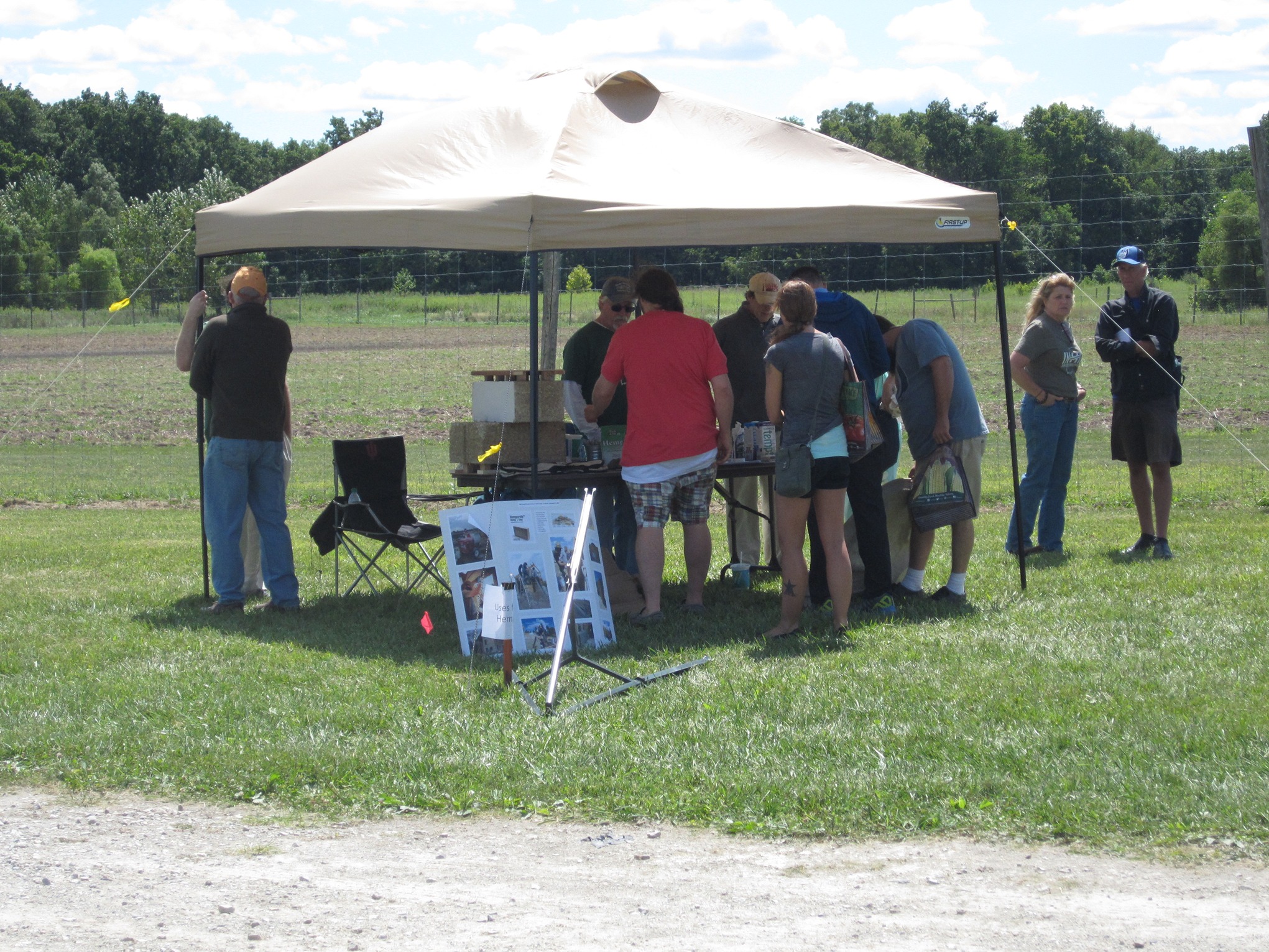Students and farmers sign-up under shade tent for Purdue researchers