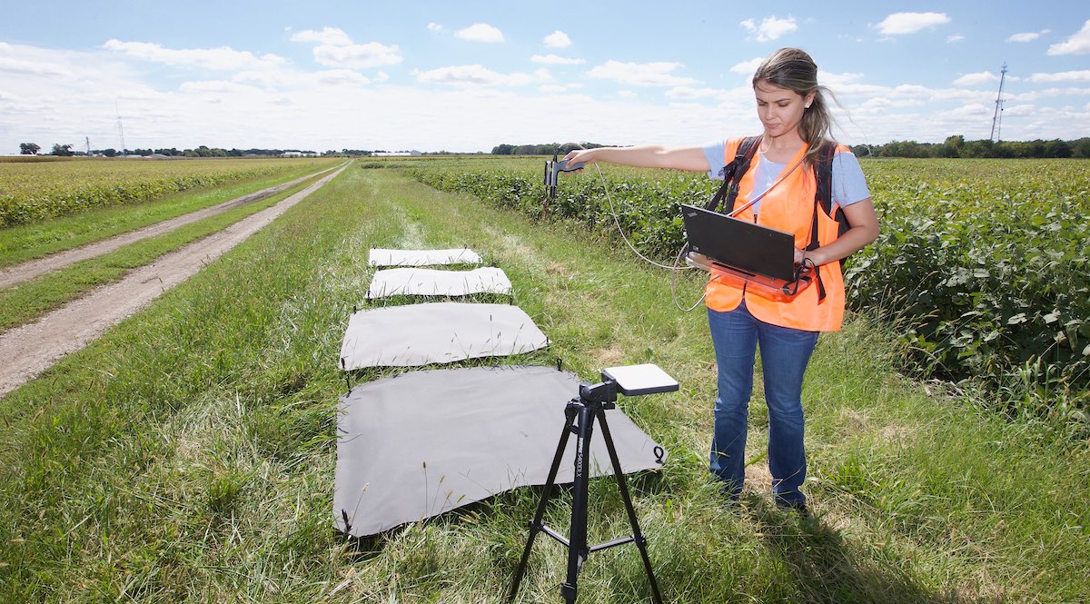 Student working with a computer and advance technology on a field