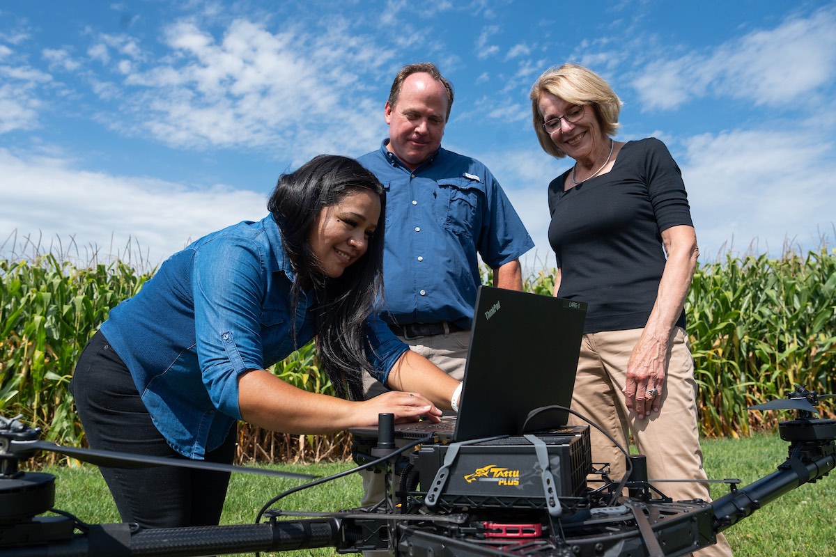 researcher and two instructors using laptop outdoors 