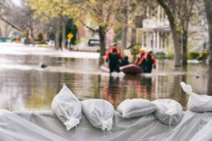 Flood Protection Sandbags with flooded homes in the background (Montage)