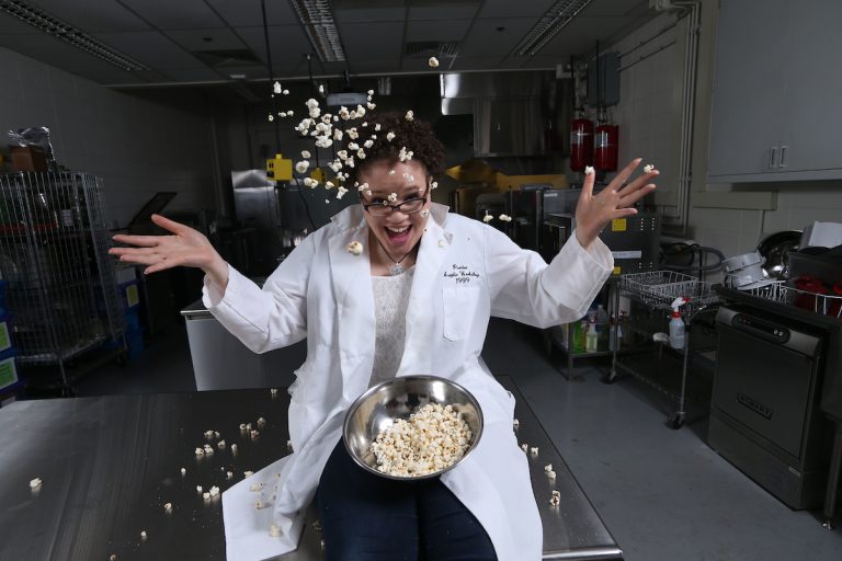 woman tossing popcorn in the air 