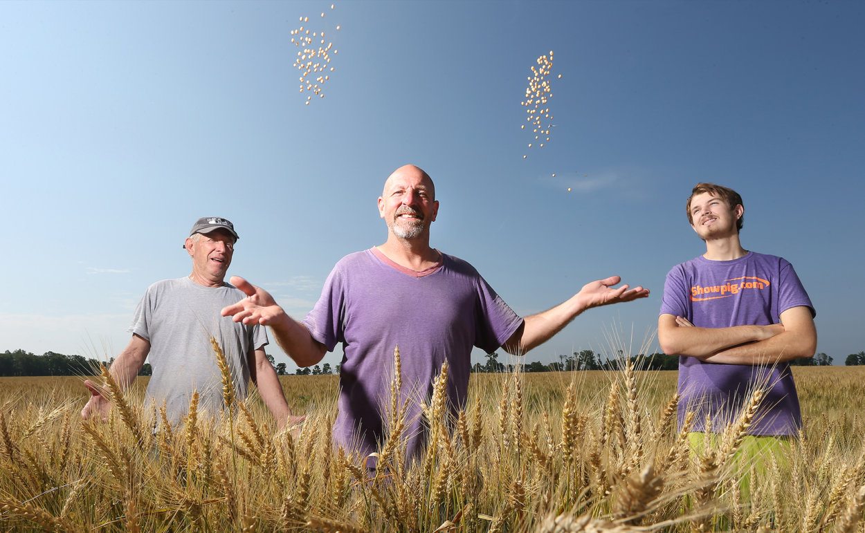 a men tossing soybeans in the air