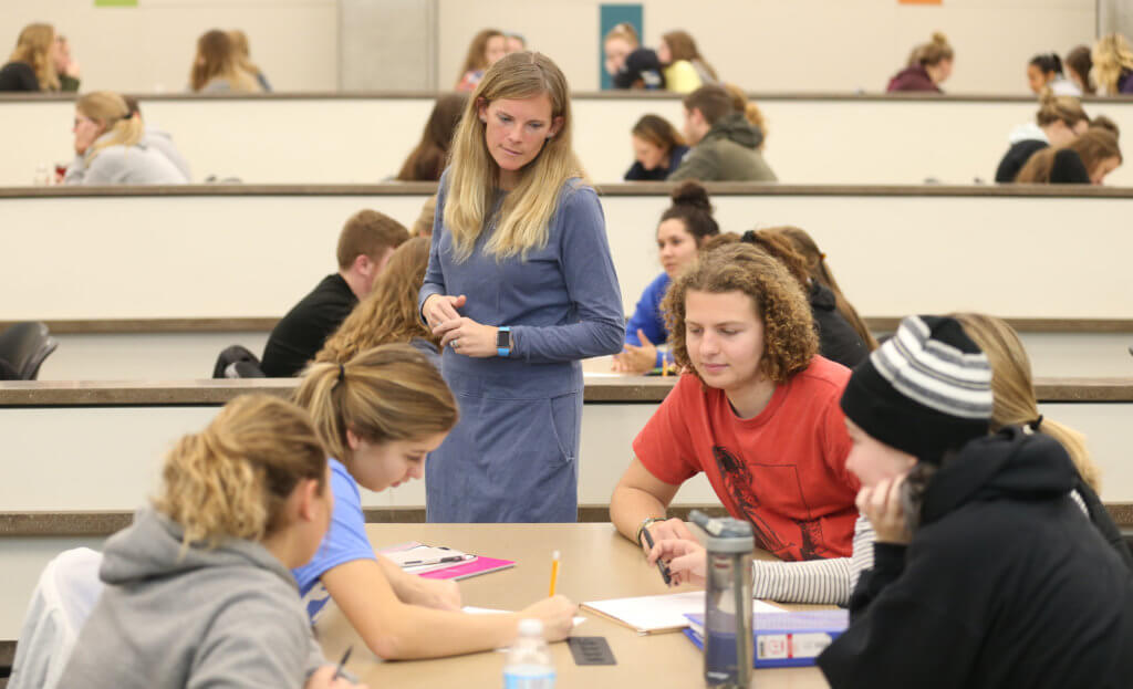 Female instructure checking on her students