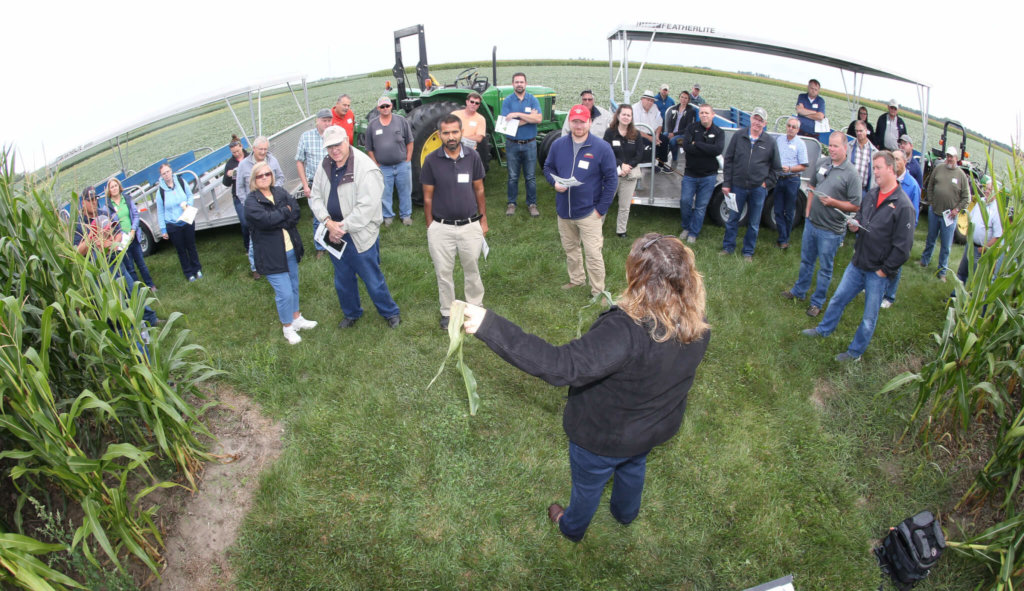 talenko talking to farmers, outdoors 