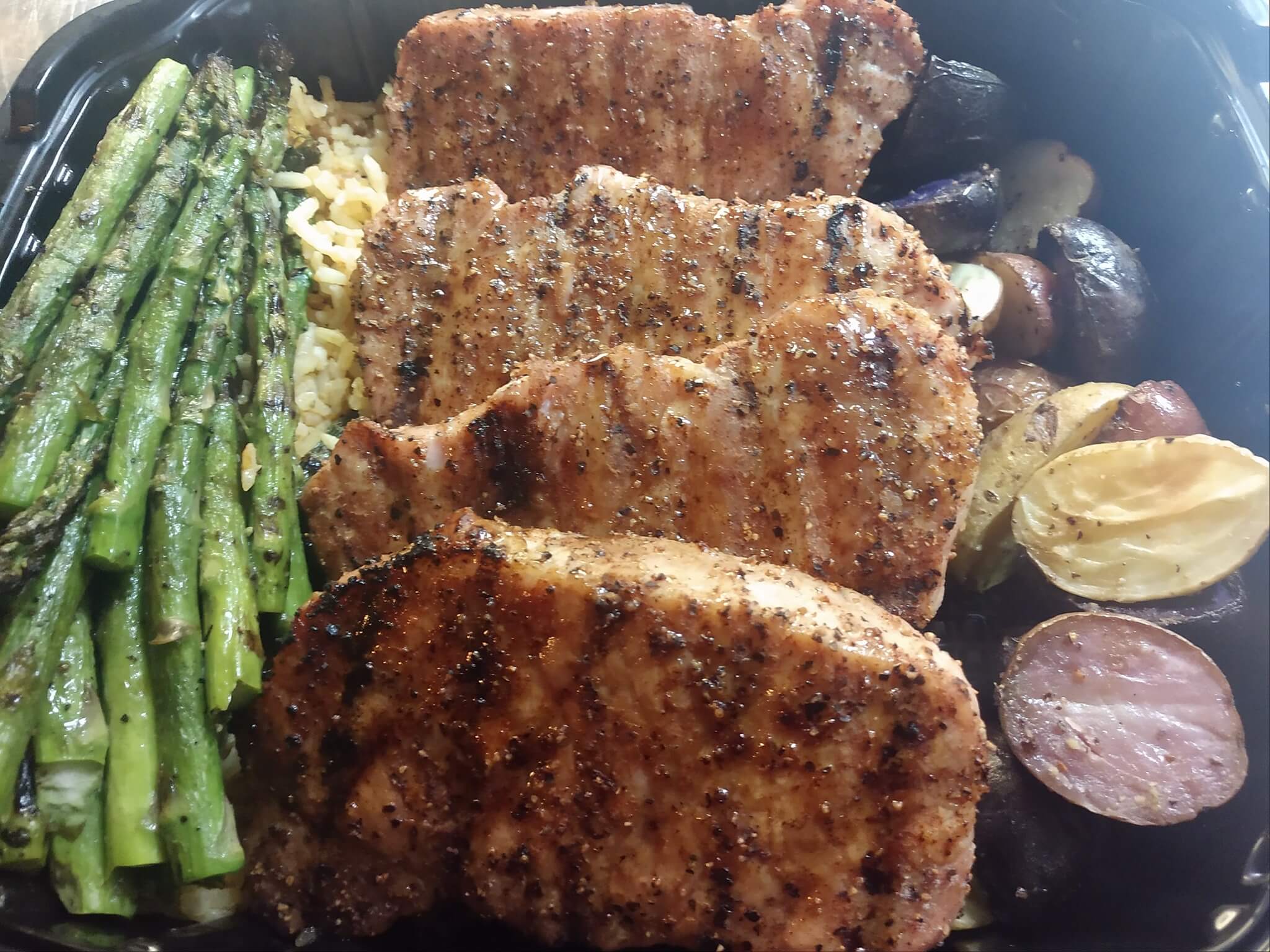 Chicken filets, asparagus and others vegetables arranged in a plate 