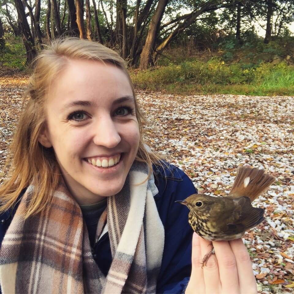 Outcalt with a Hermit Thrush bird in her hand