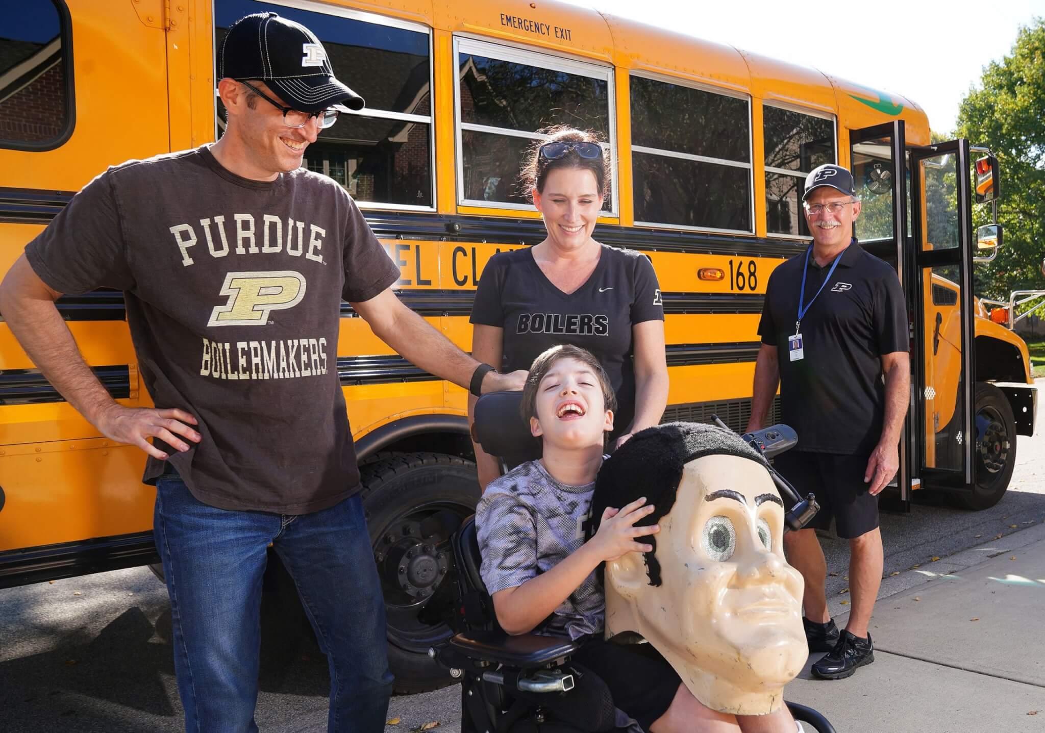 Once Carmel, Ind. bus driver Van Betulius (right) told Todd, Liz and Brayden Krueger he had once been Purdue Pete, they all became Boiler buddies for life. (Photo by Tom Campbell)