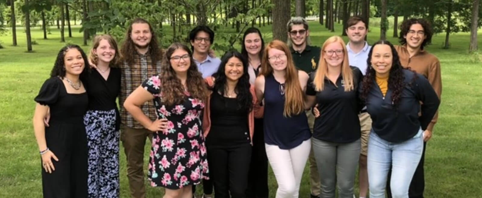 Forest Products students outdoors, green forest on the background