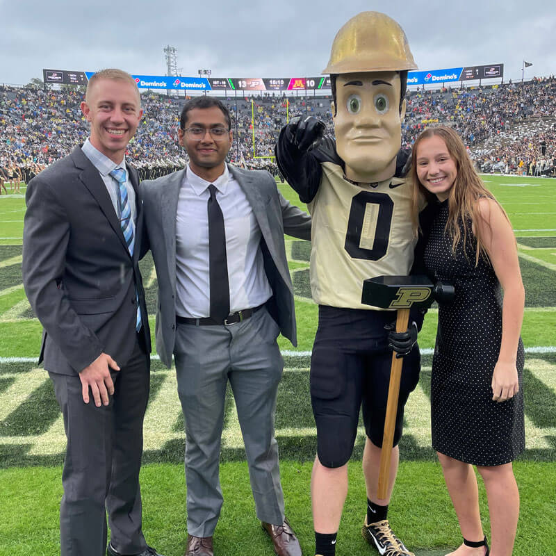 Austin and Kathryn with Purdue Pete mascot during homecoming celebration at the stadium