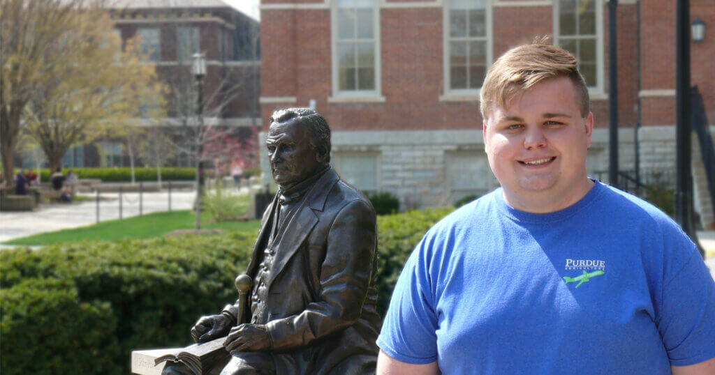 Cameron Matthews smilingin a sunny day (photo outdoors in campus)