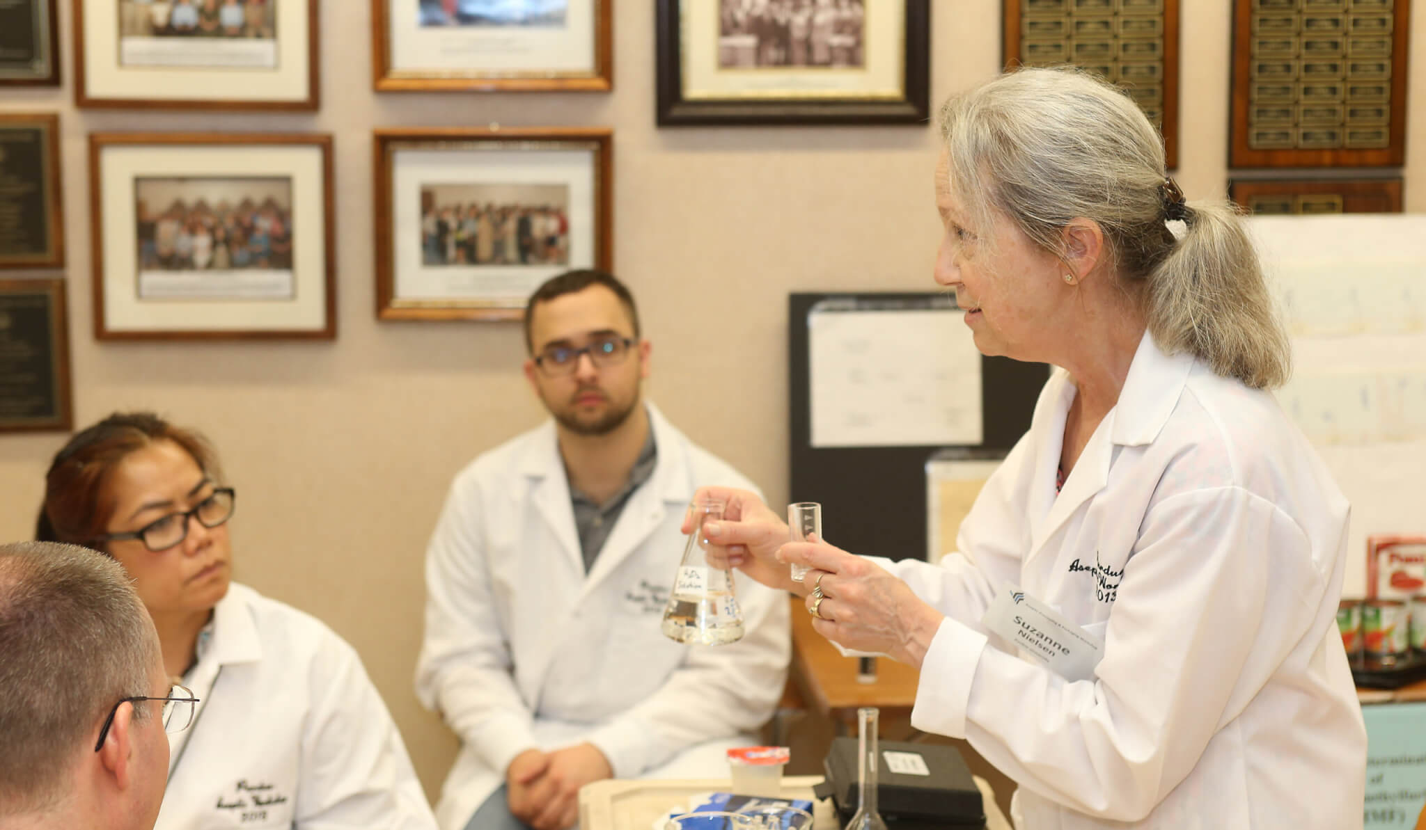 Nielsen in a lab coat with others (Photo by Tom Campbell)