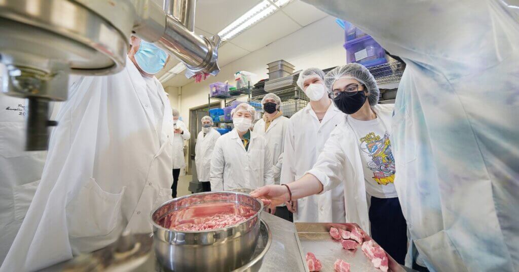 Group of research people grinding meat