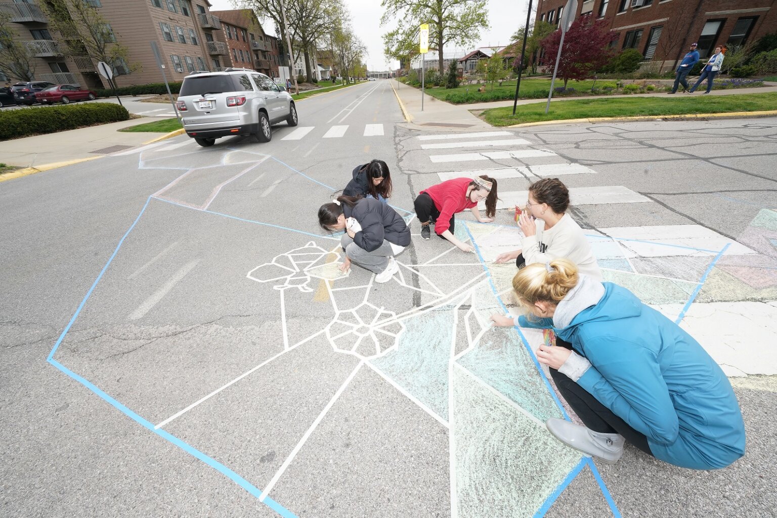 Image of students doing some chalk drawing decoration on the street
