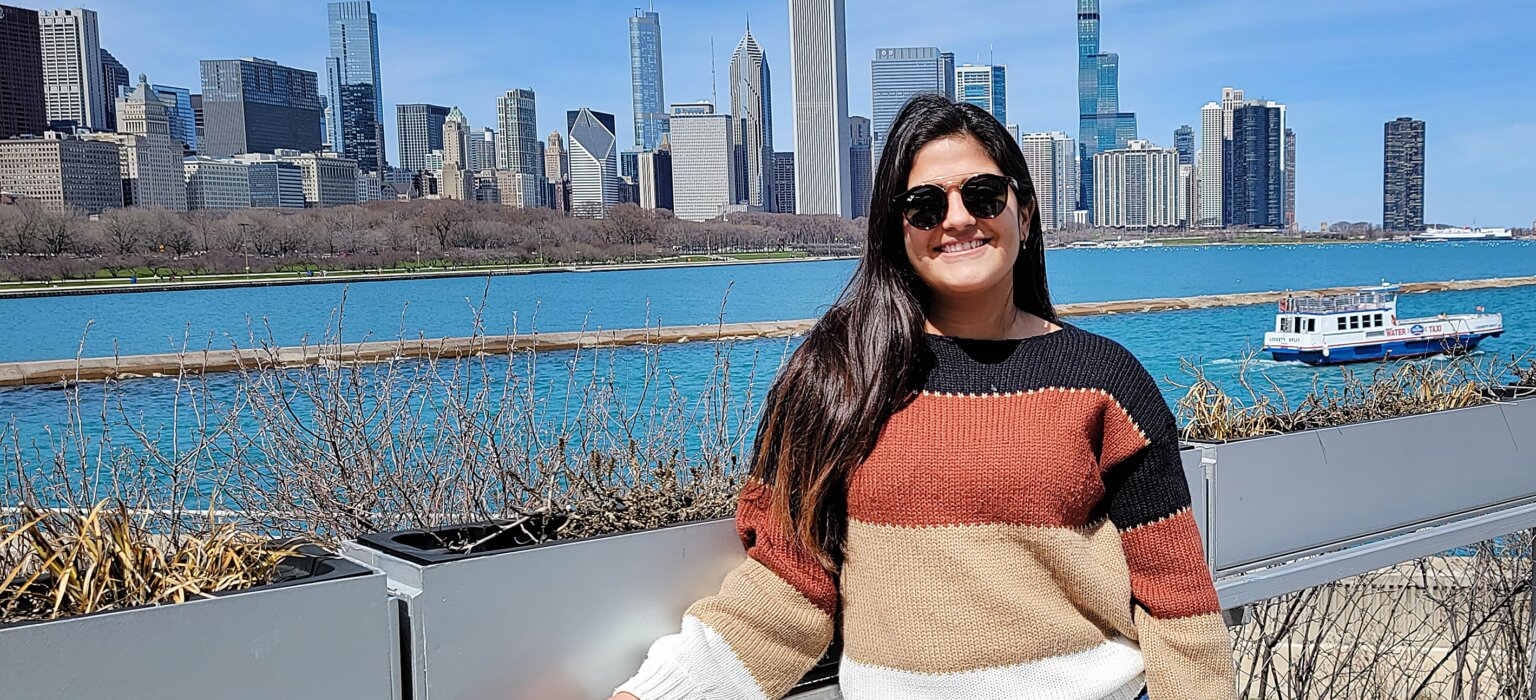 Picture of a young female outdoors, river and city in the background 