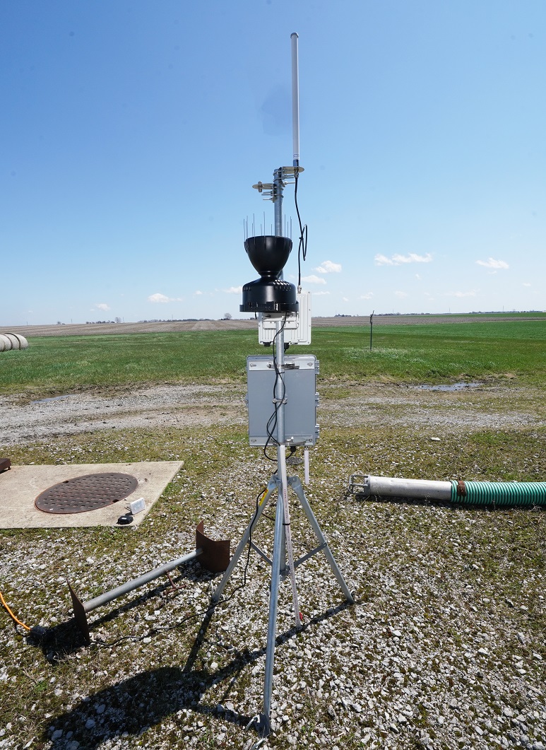 LoRaWAN kit installed on a portable stand. The kit includes a LoRaWAN gateway device and antenna; a microcomputer to store all sensor data; a rain gauge with soil sensor to determine soil moisture; two other soil sensors for topsoil moisture, temperature, humidity, atmospheric pressure and light intensity; and two GPS trackers.