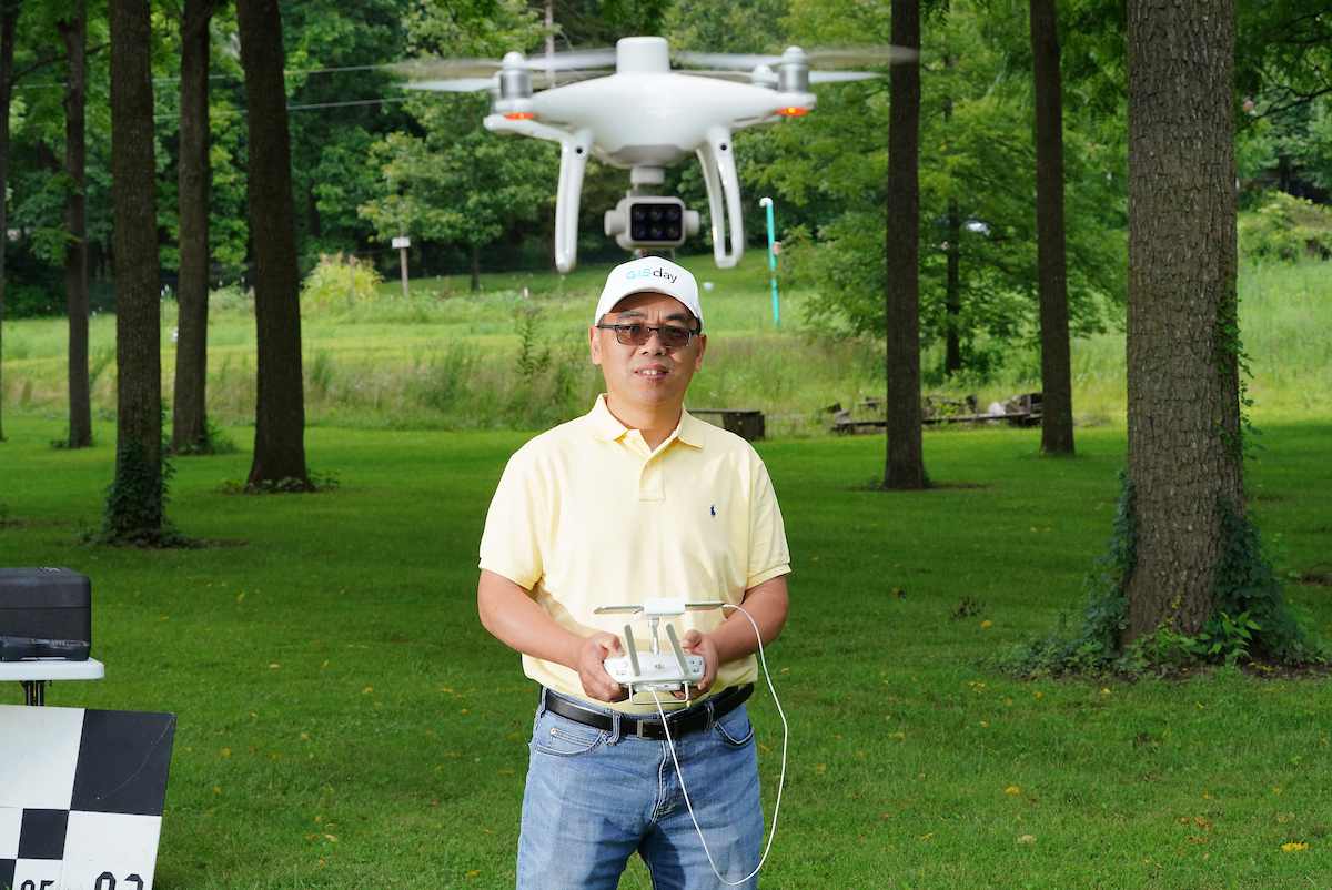 Professor Fei flying drone in woods