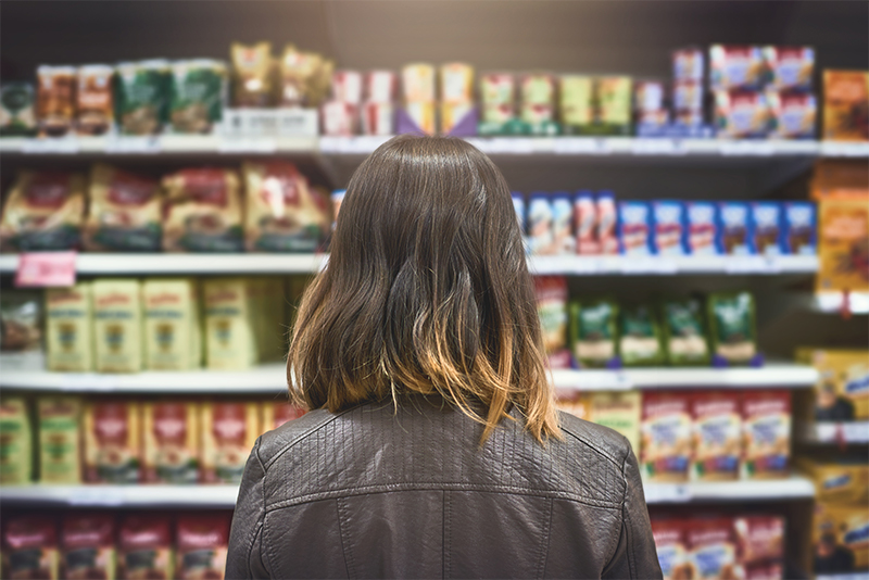 woman stands in grocery store aisle