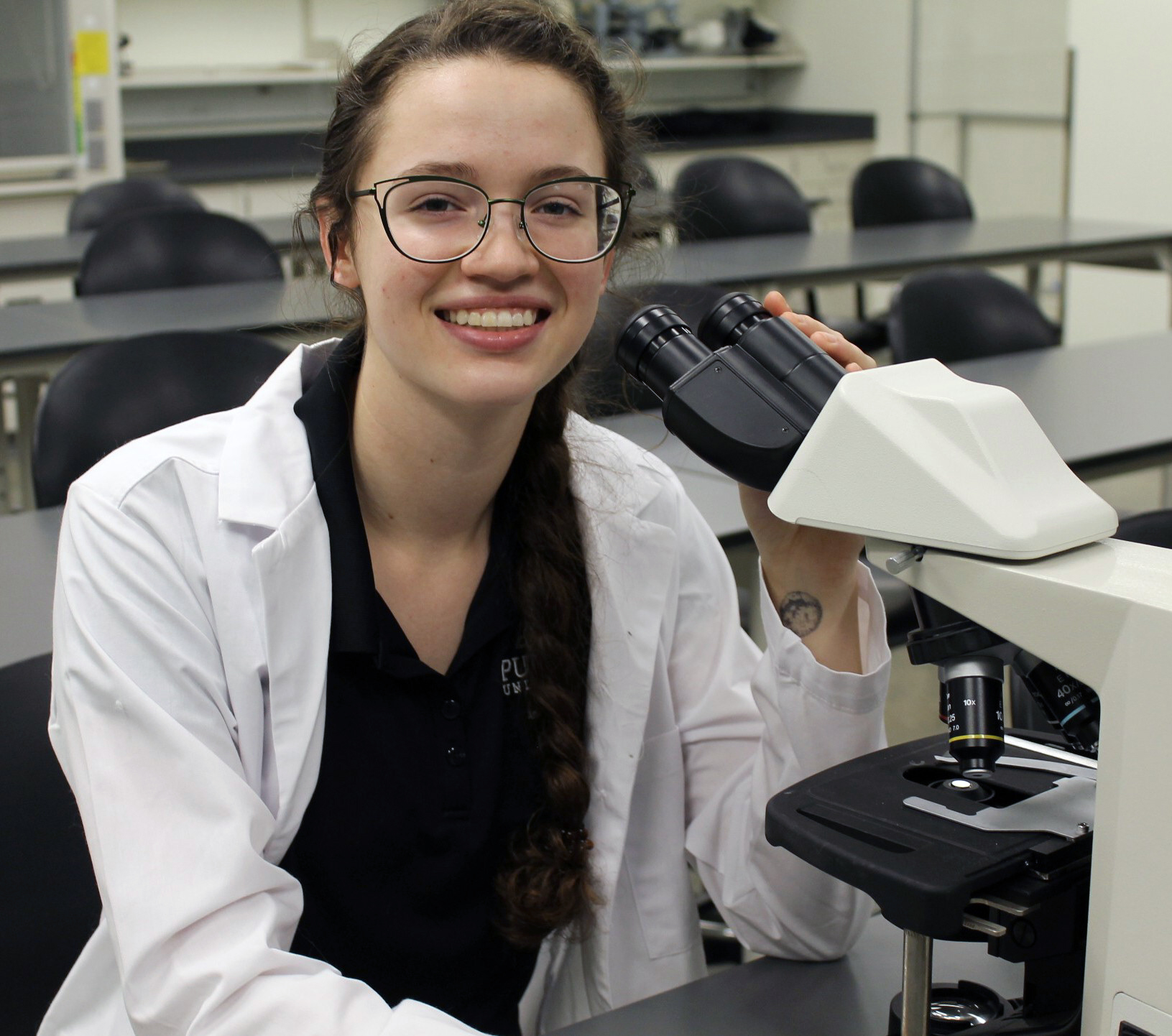 Emma Zaicow uses a microscope to look closely at bacteria.