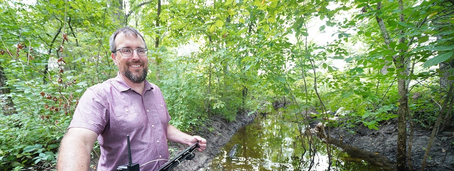 Keith Cherkauer stands in a body of water at the wetlands owned by Purdue University.