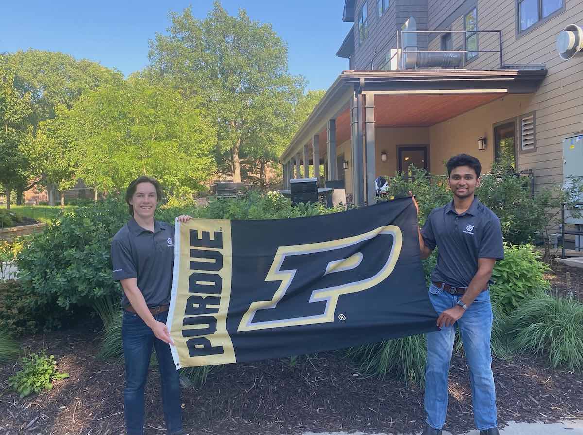 Michael Heraty, left, and Dev Patel, right, stand outside their Minnesota residence with a Purdue flag.
