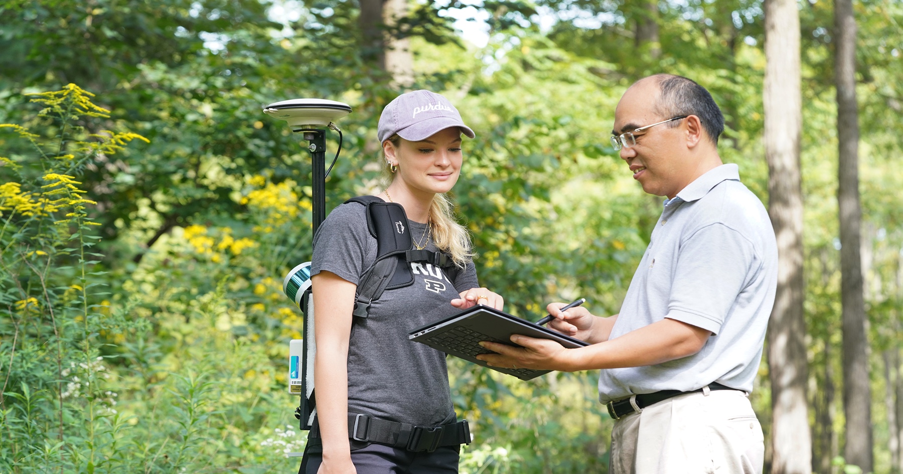 Purdue undergraduate Avery Fess works in the field with Songlin Fei, professor of forestry and natural resources and the Dean’s Chair of Remote Sensing.