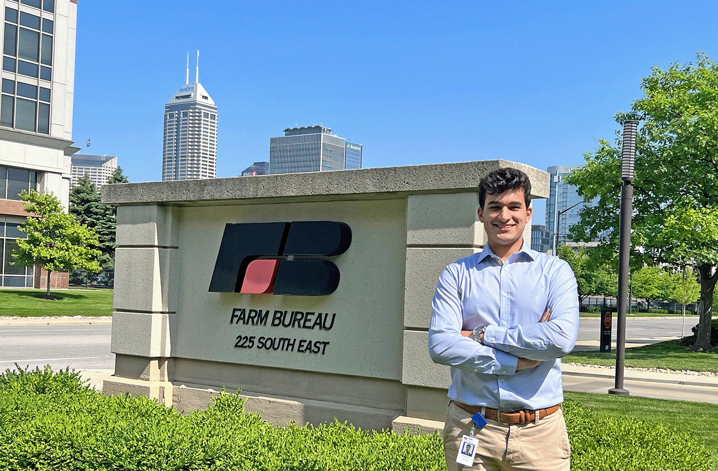 Student Jackson Daftari poses with crossed arms and a smile in front of a stone Indiana Farm Bureau sign outside