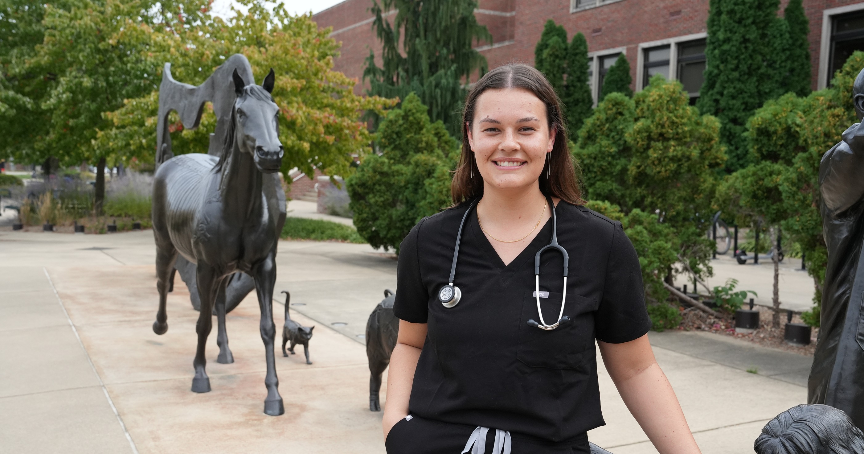 Maya Fulton stands against the Continuum sculptures outside of Lynn Hall.