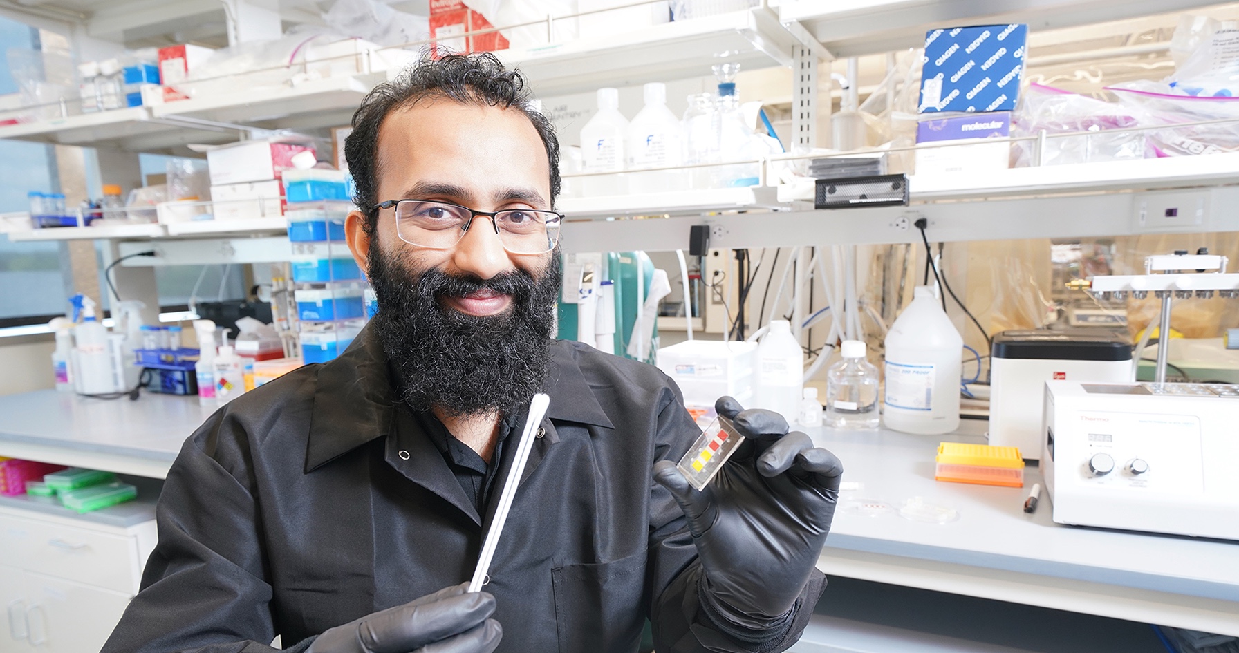 Mohit Verma, professor of agricultural and biological engineering in Purdue University’s College of Agriculture, holds a prototype for a low-cost test to diagnose Covid-19 in animals