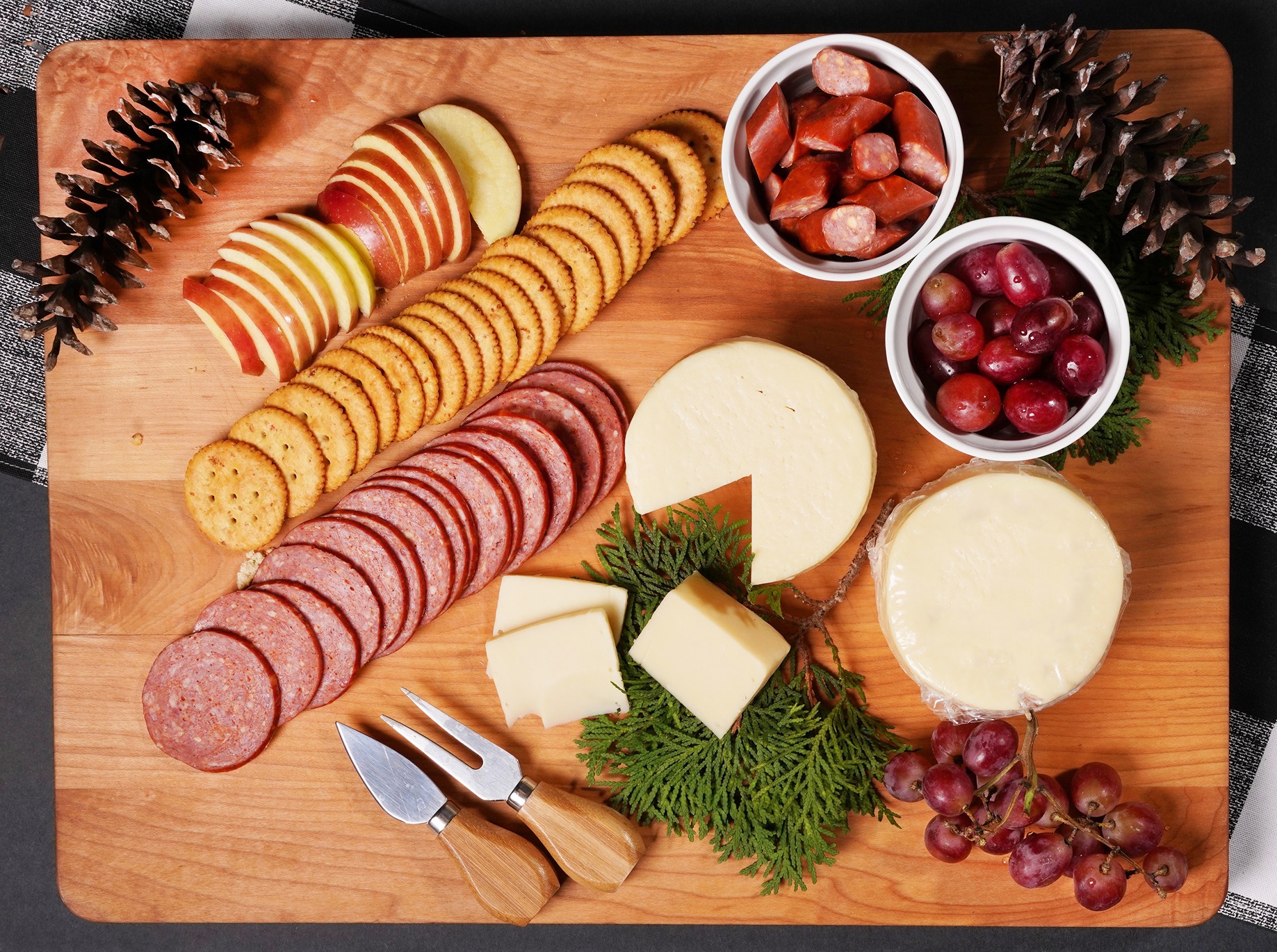 Cuts of salami and sausage are paired with other items on a charcuterie board.