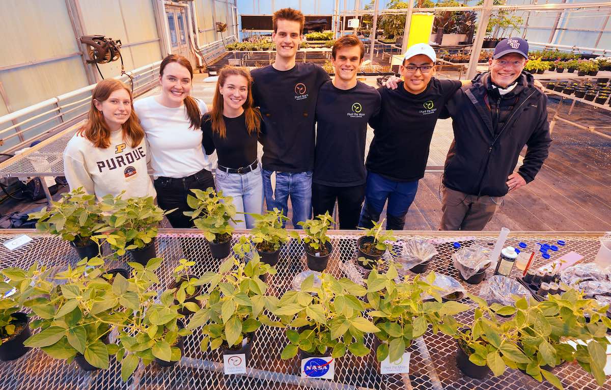 Marshall Porterfield standing with students in a greenhouse.
